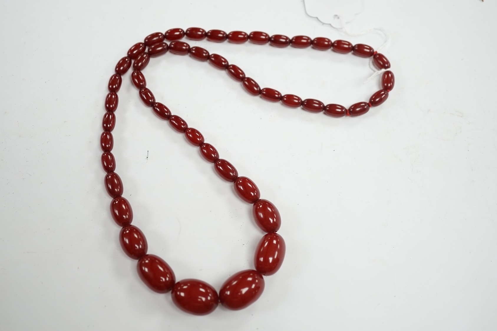 A single strand graduated simulated cherry amber bead necklace, 68cm, gross weight 52 grams. Condition - fair to good